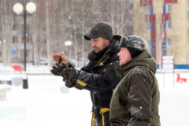Bir konuşma için buz şehrin inşaat sahasında işçiler