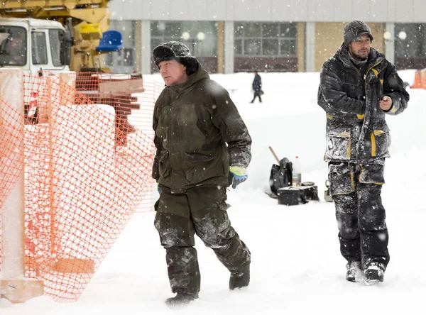 Buz kasabasının inşaat alanında iki toplayıcı yürüyor.