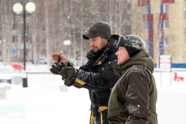 Bir konuşma için buz şehrin inşaat sahasında işçiler