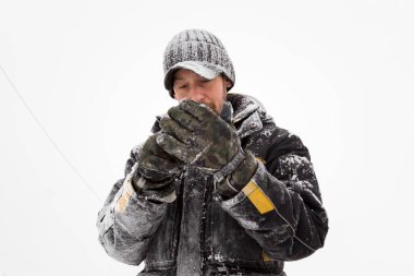 Ceketli ve siyah şapkalı bir sporcu eldiven giyer.