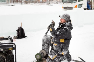 İnşaat alanında elinde keskiyle çalışan bir işçi.