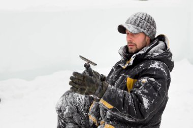 İnşaat alanında elinde keskiyle çalışan bir işçi.