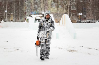 İşçi elinde testere ile buz şehre gider