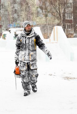 İşçi elinde testere ile buz şehre gider