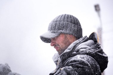 Karla kaplı bir işçinin yüzünü yakından çek.