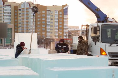 İnşaat alanına buz döşeyen üç montaj işçisi.
