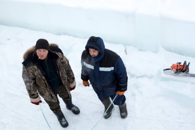Bir konuşma için buz şehrin inşaat sahasında işçiler