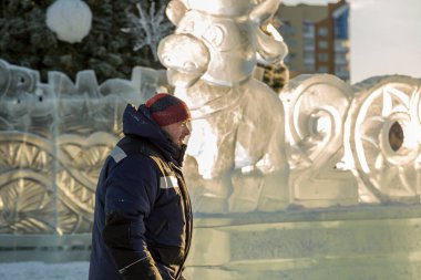 Mavi ceketli ve kırmızı örgü şapkalı bir işçi.