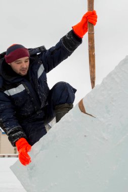 Kurucu buz bloğunda duruyor, bant askısına tutunuyor.