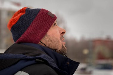 Mavi ceketli ve kırmızı örgü şapkalı bir işçi.