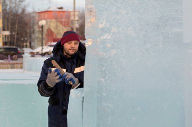 İnşaat alanında elinde keskiyle çalışan bir işçi.