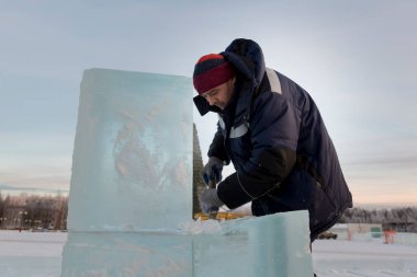 İnşaat alanında elinde keskiyle çalışan bir işçi.
