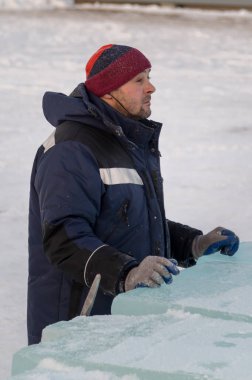 Mavi ceketli ve kırmızı örgü şapkalı bir işçi.