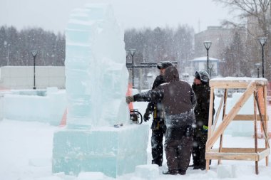 İnşaat alanındaki buz figüründeki yükleyiciler konuşuyorlar.