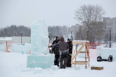 İnşaat alanındaki buz figüründeki yükleyiciler konuşuyorlar.