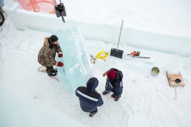 Kamyon vinci ile buz kalıplarını boşaltıyorlar.