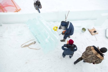 Kamyon vinci ile buz kalıplarını boşaltıyorlar.