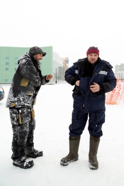Bir konuşma için buz şehrin inşaat sahasında işçiler