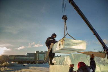 İnşaat alanına buz döşeyen iki montaj işçisi.