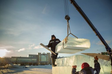 İnşaat alanına buz döşeyen iki montaj işçisi.