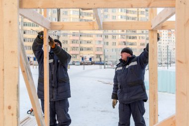 İşçi derleyici bir mezura ile tahtayı işaretler