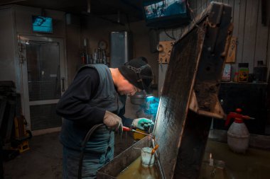 Gaz lambasıyla büyük bir araba radyatörünü kaynaklıyorum.