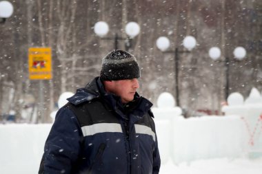 İş yerinde kapüşonlu ve yün örgü şapkalı bir işçi.