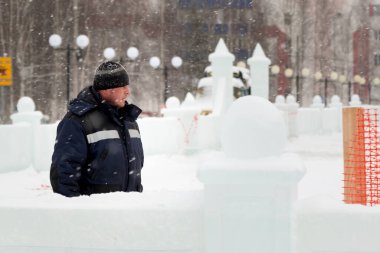 İş yerinde kapüşonlu ve yün örgü şapkalı bir işçi.