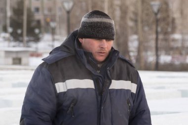 İş yerinde kapüşonlu ve yün örgü şapkalı bir işçi.