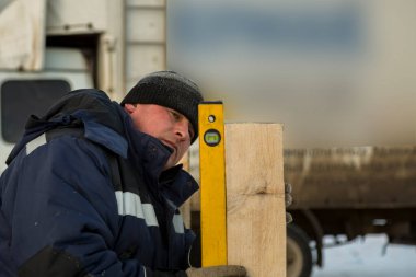 İşçi ahşap bar seviyesini ayarlar.