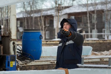 İnşaat alanında, kafasında başlığı olan mavi ceketli bir işçinin portresi.