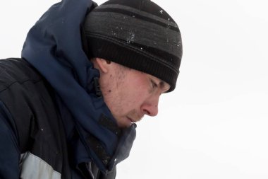 Buz kasabasının inşaat alanında mavi kapüşonlu ceketli bir işçinin portresi.