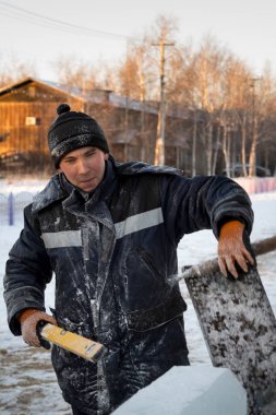 Ellerinde fırça, keski ve mertebeyle bir şantiyede tesisatçı.