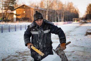 Ellerinde fırça, keski ve mertebeyle bir şantiyede tesisatçı.