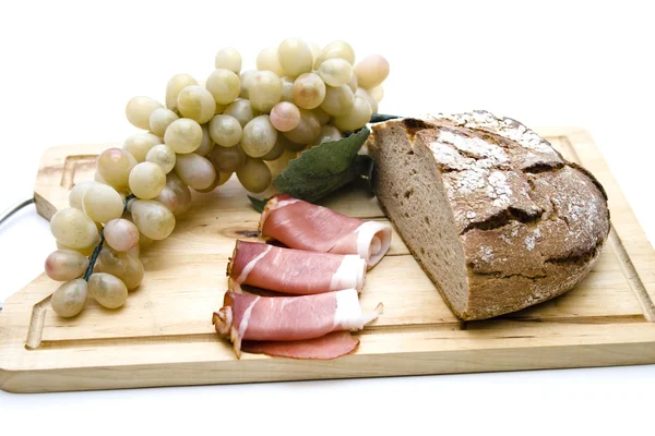 Piatto di pane, prosciutto e uva — Foto Stock