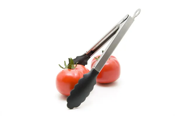Czerwony pomidor z szczypce do grilla — Zdjęcie stockowe