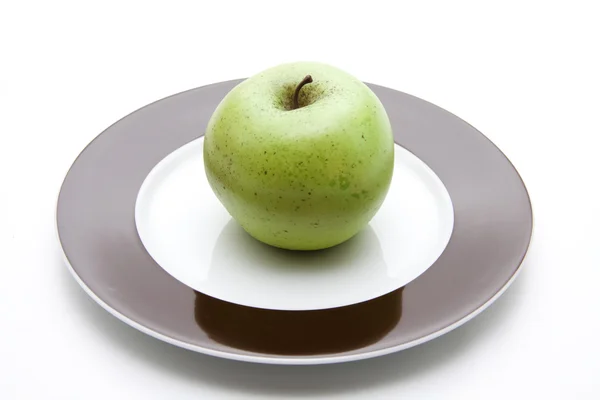 Green apple on plate — Stock Photo, Image