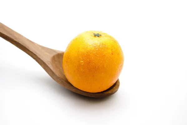 Orange on wooden spoon — Stock Photo, Image