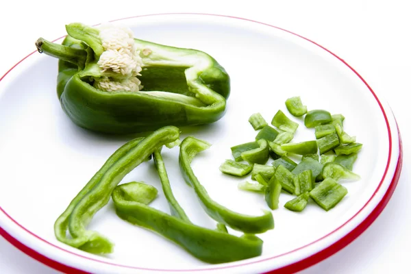 Green paprika in pieces and stripes on plate — Stock Photo, Image