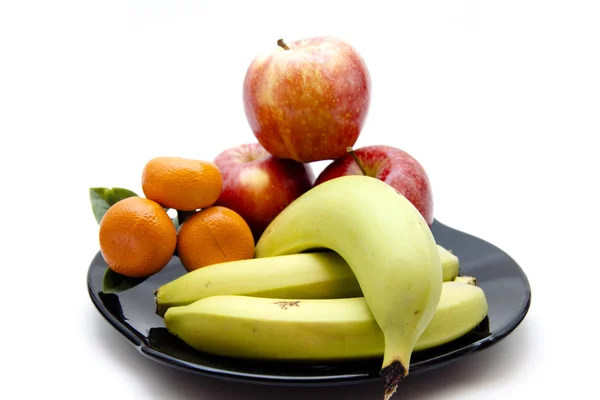 黒い皿にバナナと赤いリンゴ — ストック写真