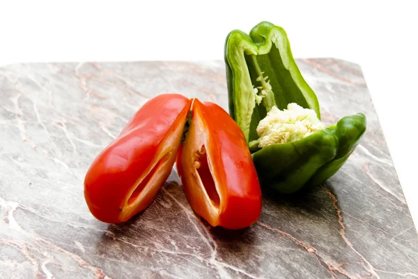 Rood en groen paprika op rand bord Stockfoto