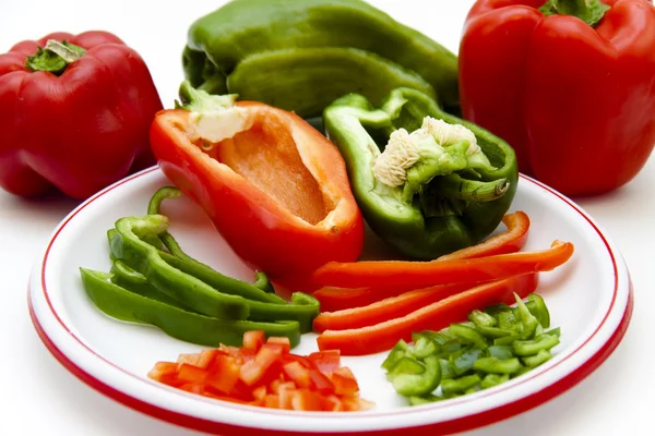 Paprika rouge et vert en morceaux et rayures sur l'assiette Image En Vente