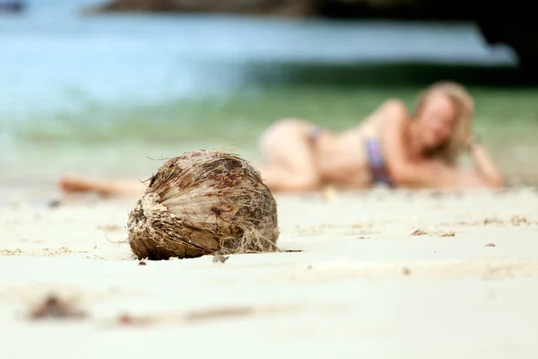 Kokos na tle z atrakcyjną dziewczyną — Zdjęcie stockowe