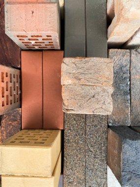 Farklı tipte tuğlalar güzel bir şekilde yeşil çimlerin üzerine istiflenmiş. Üst görünüm.