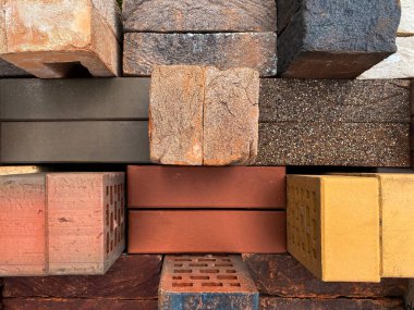 Farklı tipte tuğlalar güzel bir şekilde yeşil çimlerin üzerine istiflenmiş. Üst görünüm.