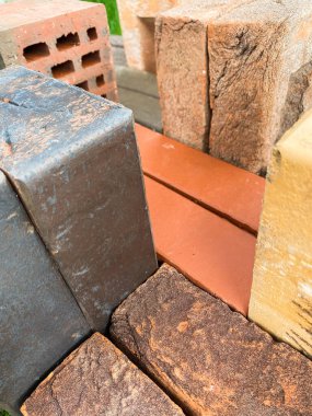 Farklı tipte tuğlalar güzel bir şekilde yeşil çimlerin üzerine istiflenmiş.