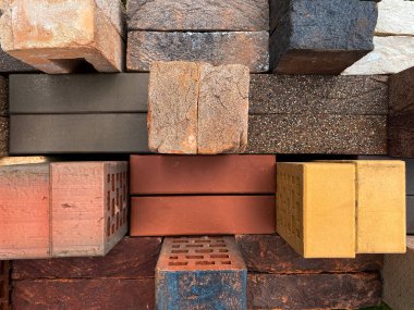 Farklı tipte tuğlalar güzel bir şekilde yeşil çimlerin üzerine istiflenmiş.