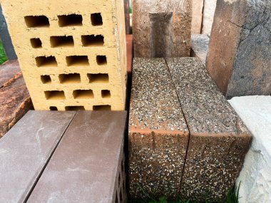 Farklı tipte tuğlalar güzel bir şekilde yeşil çimlerin üzerine istiflenmiş.