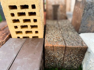 Farklı tipte tuğlalar güzel bir şekilde yeşil çimlerin üzerine istiflenmiş.