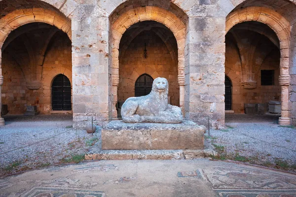 Escultura de un león recostado sobre sus pies en el patio del museo arqueológico en el casco antiguo de Rodas, Grecia — Foto de Stock